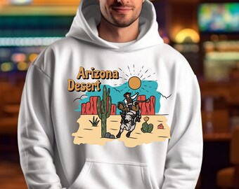 Può includere: Felpa con cappuccio bianca con un design grafico di un cowboy che cavalca un cavallo nel deserto dell'Arizona. Il testo "Arizona Desert" è stampato sulla parte anteriore della felpa.