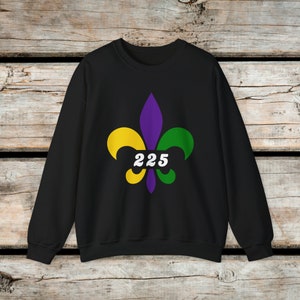 Puede incluir: Sudadera negra con un diseño de flor de lis morado, verde y amarillo y el número 225 en blanco.