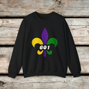 May include: Black sweatshirt featuring a purple, green and yellow fleur-de-lis design with the number "601" in white.