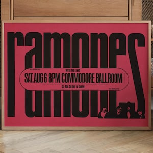 Könnte beinhalten: Ein gerahmtes Poster mit rotem Hintergrund und schwarzem Text. Das Poster zeigt den Bandnamen "Ramones" in großen, stilisierten Buchstaben. Zusätzlicher Text enthält "SAT. AUG 6 8PM COMMODORE BALLROOM" und Bilder der Bandmitglieder.