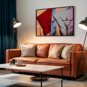 May include: A modern living room featuring a brown leather sofa with beige pillows, a white coffee table, and a framed artwork depicting a male torso in vibrant colors. Two black floor lamps flank the sofa.