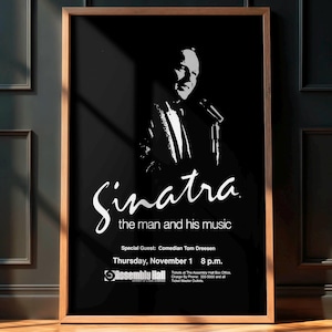 May include: A framed poster with a black background and a white silhouette of Frank Sinatra holding a microphone. The poster includes the text "Sinatra the man and his music" and event details.