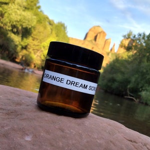 Orange Dream Body Scrub, 4oz jar: An exfoliating sugar scrub that invigorates your senses with a delicious aroma.