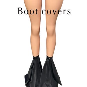 Puede incluir: Cubiertas de botas negras con un diseño acampanado y una fila de diamantes de imitación alrededor de la parte superior.