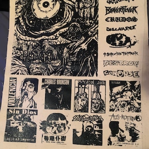 May include: A black and white screen print on a beige fabric. The print features various illustrations and text, including band names like "WARSORE" and "DESTROY". Other text includes "VIOLENCIA" and "Sin Dios". The artwork has a punk rock aesthetic.
