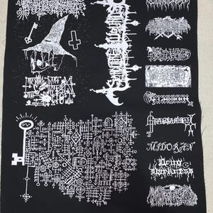 May include: Black fabric patch featuring multiple white graphic designs. Includes a key, a witch's hat, and various stylized text elements. The patch has a dark, gothic aesthetic.