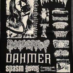 May include: Black fabric patch with white graphic text and illustrations. Features a portrait of a person wearing a leather muzzle, and the words "cockandballtorture" vertically. Other text includes "Dahmer" and band names.