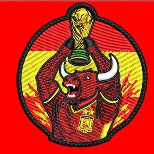 Puede incluir: Un parche bordado circular que muestra un toro rojo con cuernos blancos sosteniendo un trofeo dorado sobre su cabeza. El toro viste una camiseta roja con un emblema amarillo y dos estrellas amarillas. El fondo muestra la bandera de España.