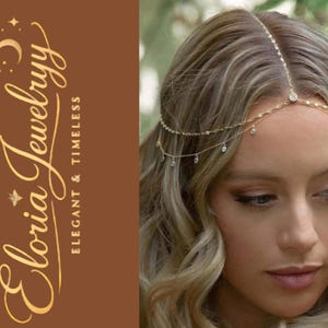 May include: A gold-toned headpiece with small, sparkling crystals is worn on a woman's head. The headpiece is delicate and elegant, with a series of chains and crystals. The image also features the logo "Eloria Jewelryy" in gold script on a brown background.