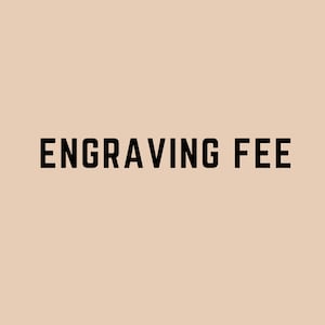 以下が含まれることがあります： 薄いベージュの背景に黒い文字で「Engraving Fee」と書いてあります。