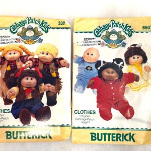 Op de afbeelding: Twee Butterick naaipatroon enveloppen voor Cabbage Patch Kids kleding. De linker envelop, nummer 339, toont drie poppen in western-stijl outfits. De rechter envelop, nummer 6507, toont drie poppen in pyjama's en vrijetijdskleding.