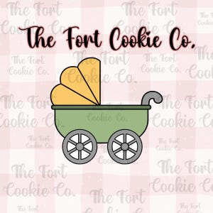 May include: A cookie cutter in the shape of a baby carriage. The carriage is green with yellow accents and gray wheels. The text "The Fort Cookie Co." is displayed in a cursive font.