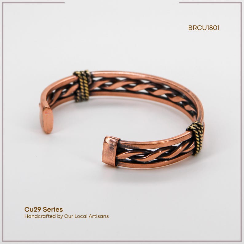 May include: Copper cuff bracelet with a braided design. The open-ended bracelet features a woven pattern and is accented with gold-colored metal at the ends. The text "Cu29 Series" and "Handcrafted by Our Local Artisans" is visible.