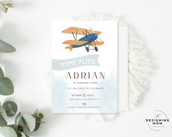 May include: A rectangular invitation card featuring a watercolor illustration of a blue and orange biplane. The text reads: TIME FLIES, ADRIAN IS TURNING THREE, FLY ON OVER TO CELEBRATE, SEPTEMBER 11 4:00 PM, 12345 Laketrail Cove, Buena Park CA, RSVP Aimee + 123456789 by 5th September.