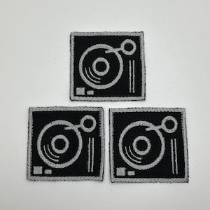 May include: Three black and gray embroidered iron-on patches featuring a stylized record player design.