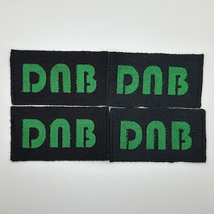 May include: Four black fabric patches with the word "DAB" embroidered in green.
