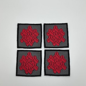 May include: Four square embroidered patches with a red geometric design on a gray background.