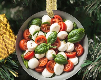 May include: A round, flat ornament featuring a high-resolution image of a caprese salad with sliced red tomatoes, white mozzarella balls, and fresh green basil leaves. The ornament is suspended by a shimmering gold ribbon for hanging.