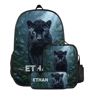 Puede incluir: Un conjunto de mochila, bolsa de almuerzo y estuche con un estampado gráfico de una pantera negra en la selva. Cada artículo muestra el nombre ETHAN en letras blancas sobre el follaje verde y el rostro de la pantera en primer plano.
