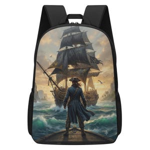 Puede incluir: Una mochila negra con un gráfico impreso de una persona con abrigo largo de pie en la cubierta de un barco, mirando hacia un gran velero de velas oscuras en un mar turbulento bajo un cielo dorado con aves y islas distantes.