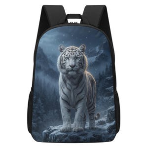 May include: A black backpack featuring a large, high-resolution print of a white tiger standing on a snowy, rocky cliff. The background depicts a dark, wintry mountain landscape with pine trees and falling snow. The bag has black shoulder straps.