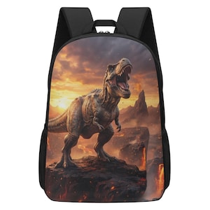 May include: A black backpack featuring a large, detailed graphic print of a Tyrannosaurus Rex standing on a rocky cliff. The background depicts a dramatic volcanic landscape with glowing lava, dark mountains, and a fiery orange sunset sky.