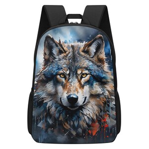 May include: A black backpack featuring a large, detailed graphic print of a wolf's face on the front panel. The wolf has amber eyes and fur rendered in shades of grey, brown, and blue with abstract paint-like splatters and drips.