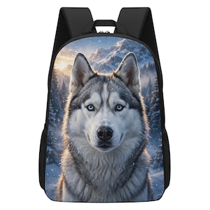 May include: A black backpack featuring a high-resolution graphic print of a Siberian husky with striking blue eyes. The dog is centered against a snowy mountain landscape with pine trees and soft sunlight, framed by black straps and side mesh pockets.