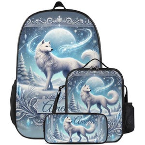 May include: A backpack, lunch bag, and pencil case set featuring a white wolf in a snowy, moonlit winter landscape. Each item displays the name Amelia in elegant script, surrounded by intricate silver filigree, pine trees, and glowing crystals.
