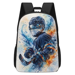Puede incluir: Una mochila negra con un gráfico vibrante de estilo acuarela de un jugador de hockey sobre hielo que lleva un casco con visera reflectante, sostiene un palo de hockey, rodeado de salpicaduras de pintura azul y naranja y cristales de hielo.