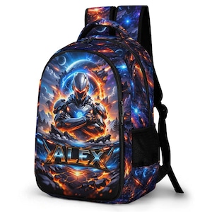 May include: A backpack featuring a vibrant space-themed graphic with a futuristic armoured character in the centre. The name ALEX is printed in bold, metallic-style lettering at the bottom. The design includes glowing orange and blue energy effects.