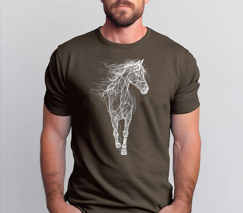 May include: A dark olive green t-shirt featuring a white line art illustration of a running horse. The horse design is detailed with flowing lines, creating a dynamic and artistic representation of the animal. The shirt is a classic crew neck style.