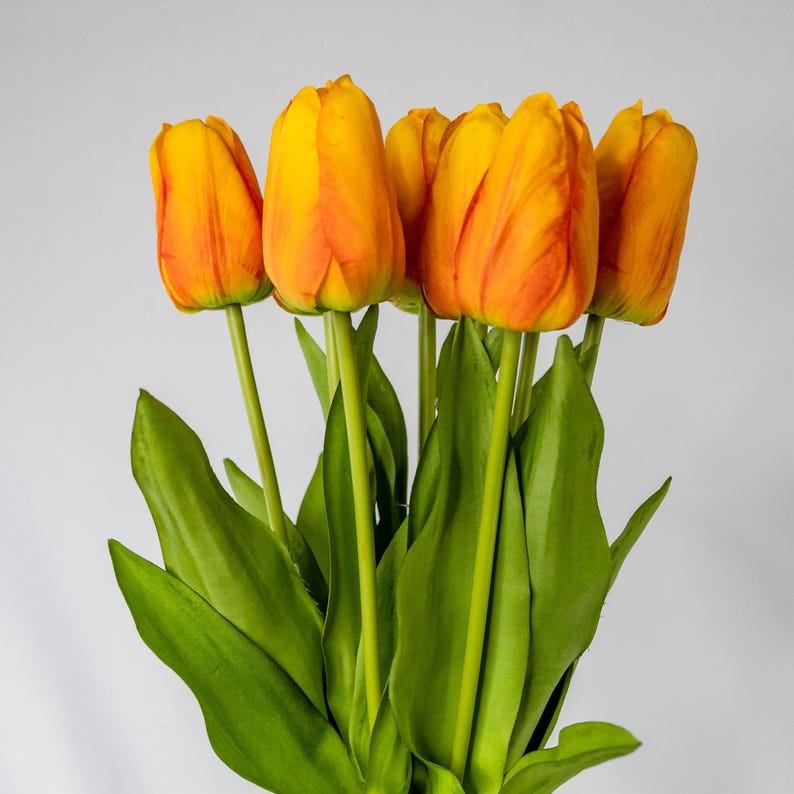 Orange real touch tulip stem with realistic petals and wired leaves.