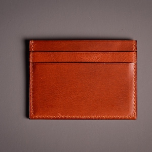 Découvrez notre portefeuille fin en cuir, conçu pour homme ou femme, alliant élégance et praticité. Fabriqué à la main avec un cuir 100 % premium, cet accessoire sophistiqué dispose d'une capacité de rangement pour environ 4 cartes de crédit. Son design épuré et chic s'adapte parfaitement à votre style au quotidien. Offrez-vous ou à un proche ce portefeuille artisanal, alliant style et fonctionnalité. Parfait pour un usage quotidien ou comme cadeau spécial!