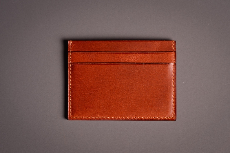 Découvrez notre portefeuille fin en cuir, conçu pour homme ou femme, alliant élégance et praticité. Fabriqué à la main avec un cuir 100 % premium, cet accessoire sophistiqué dispose d'une capacité de rangement pour environ 4 cartes de crédit. Son design épuré et chic s'adapte parfaitement à votre style au quotidien. Offrez-vous ou à un proche ce portefeuille artisanal, alliant style et fonctionnalité. Parfait pour un usage quotidien ou comme cadeau spécial!