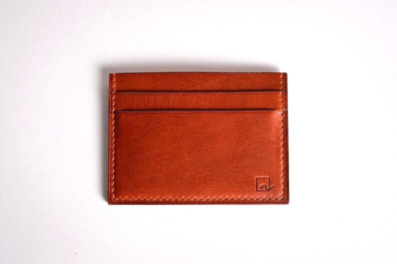 Découvrez notre portefeuille fin en cuir, conçu pour homme ou femme, alliant élégance et praticité. Fabriqué à la main avec un cuir 100 % premium, cet accessoire sophistiqué dispose d'une capacité de rangement pour environ 4 cartes de crédit. Son design épuré et chic s'adapte parfaitement à votre style au quotidien. Offrez-vous ou à un proche ce portefeuille artisanal, alliant style et fonctionnalité. Parfait pour un usage quotidien ou comme cadeau spécial!