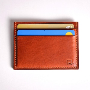 Découvrez notre portefeuille fin en cuir, conçu pour homme ou femme, alliant élégance et praticité. Fabriqué à la main avec un cuir 100 % premium, cet accessoire sophistiqué dispose d'une capacité de rangement pour environ 4 cartes de crédit. Son design épuré et chic s'adapte parfaitement à votre style au quotidien. Offrez-vous ou à un proche ce portefeuille artisanal, alliant style et fonctionnalité. Parfait pour un usage quotidien ou comme cadeau spécial!