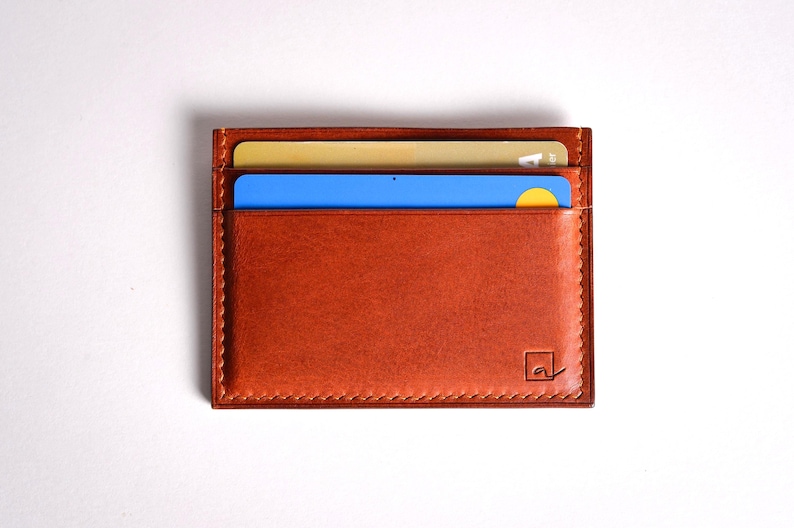Découvrez notre portefeuille fin en cuir, conçu pour homme ou femme, alliant élégance et praticité. Fabriqué à la main avec un cuir 100 % premium, cet accessoire sophistiqué dispose d'une capacité de rangement pour environ 4 cartes de crédit. Son design épuré et chic s'adapte parfaitement à votre style au quotidien. Offrez-vous ou à un proche ce portefeuille artisanal, alliant style et fonctionnalité. Parfait pour un usage quotidien ou comme cadeau spécial!