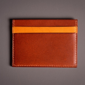 Découvrez notre portefeuille fin en cuir, conçu pour homme ou femme, alliant élégance et praticité. Fabriqué à la main avec un cuir 100 % premium, cet accessoire sophistiqué dispose d'une capacité de rangement pour environ 4 cartes de crédit. Son design épuré et chic s'adapte parfaitement à votre style au quotidien. Offrez-vous ou à un proche ce portefeuille artisanal, alliant style et fonctionnalité. Parfait pour un usage quotidien ou comme cadeau spécial!