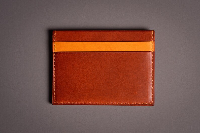 Découvrez notre portefeuille fin en cuir, conçu pour homme ou femme, alliant élégance et praticité. Fabriqué à la main avec un cuir 100 % premium, cet accessoire sophistiqué dispose d'une capacité de rangement pour environ 4 cartes de crédit. Son design épuré et chic s'adapte parfaitement à votre style au quotidien. Offrez-vous ou à un proche ce portefeuille artisanal, alliant style et fonctionnalité. Parfait pour un usage quotidien ou comme cadeau spécial!