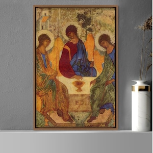 May include: A religious icon painting depicting three figures, likely representing the Holy Trinity, seated together. The figures are dressed in colorful robes and have halos. The central figure holds a chalice in their hand. The painting is framed in a wooden frame.