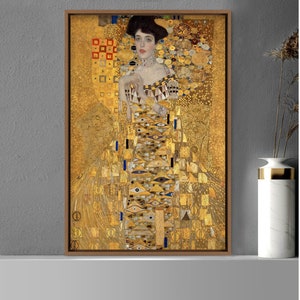 May include: A framed painting of a woman in a gold dress with a geometric pattern. The background is also gold with a geometric pattern.