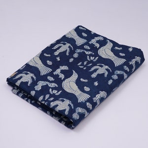 Peut inclure: Un tissu en coton bleu avec un motif de fleurs et d'oiseaux blancs. Le tissu est pli&eacute; en deux et a une surface textur&eacute;e.