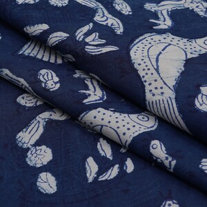Peut inclure: Tissu bleu indigo avec un motif imprim&eacute; blanc de poissons stylis&eacute;s et de feuilles. Le tissu a une texture douce.