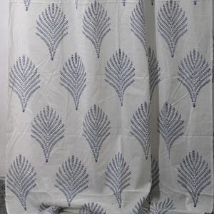 May include: White fabric with a repeating pattern of navy blue leaf-like shapes. The design features stylized, symmetrical leaf motifs arranged across the fabric's surface. The fabric appears to be cotton or a similar lightweight material.