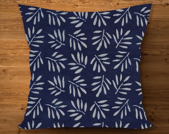May include: Square throw pillow with a navy blue background and a repeating pattern of white leaf-like shapes. The pillow is likely made of fabric and designed for decorative use on a couch or bed.