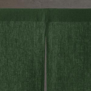 May include: A dark forest green curtain featuring a textured fabric weave. The curtain is constructed with a horizontal top rod pocket header and a vertical centre split that divides the fabric into two distinct panels, creating a classic noren style.