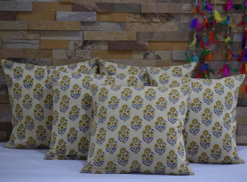 Pode incluir: Um conjunto de seis almofadas decorativas com fundo branco e um padr&atilde;o floral em tons de azul e amarelo.