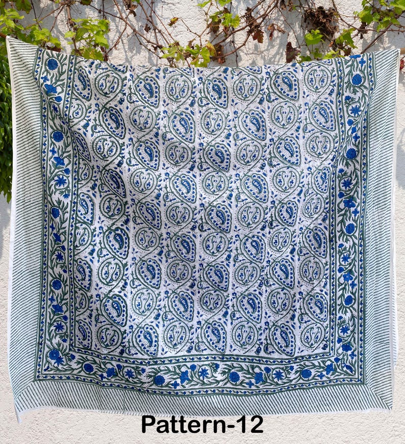K&ouml;nnte beinhalten: Eine wei&szlig;e Baumwolldecke mit einem blauen und gr&uuml;nen Paisley-Muster. Die Decke hat einen Rand mit einem gestreiften Muster. Der Text "Pattern-12" ist unten im Bild gedruckt.