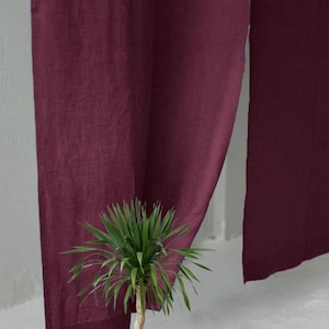 Pode incluir: Um par de cortinas em tom bord&ocirc; profundo feitas de um tecido texturizado que pende verticalmente. As cortinas apresentam um design simples de corte reto com uma trama vis&iacute;vel, criando um efeito de bloco de cor s&oacute;lida de cima a baixo.